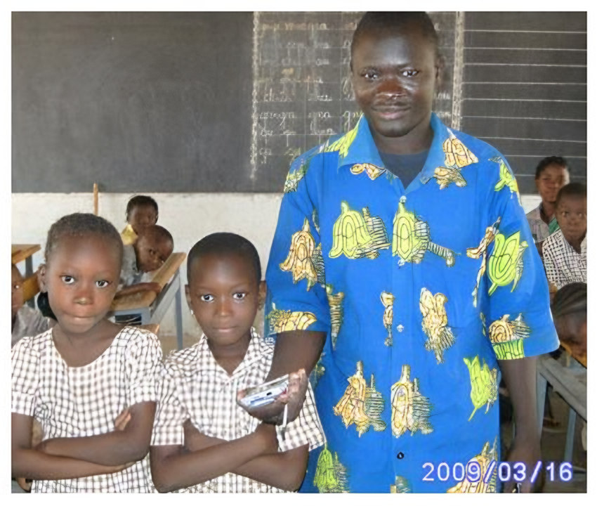 un homme en chemise bleue à motifs avec deux enfants en uniforme (daté 2009/03/16)